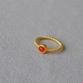 Macro detail of twisted rope texture and red stone bezel setting on a gold-plated ring - US 7 / Red Agate