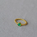 Macro view of gold braided brass ring featuring a central green natural stone inlay - US 7 / Green Agate