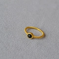 Macro detail of gold plated twisted rope ring with a round black gemstone inlay - US 7 / Black Agate