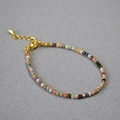 Dettaglio ravvicinato di perle in pietra naturale sfaccettate su bracciale dorato - Agata di Alashan