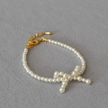 Dettaglio della collana con fiocco di perle con chiusura a moschettone dorata e catena - Bracciale