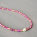 Detail of colorful beads with gold spacers and a white baroque pearl on a choker necklace - Pink Purple