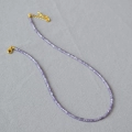 Detail view of the light purple crystal beads and gold metal clasp on the necklace - Purple