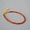 Macro view of red agate faceted beads with gold lobster clasp and extension chain - Red Agate Bracelet