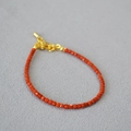 Dettaglio macro di perle di agata rossa quadrate con chiusura a moschettone dorata e catena - Braccialetto di perle agata Nanhong