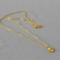 Collier minimaliste à pendentif soleil doré avec une pierre turquoise sur feutre gris - Or