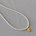 Dettaglio del ciondolo malocchio turchese e perle bianche su collana minimalista - Stile perla con ciondolo a forma di sole / Bianco