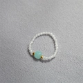 Anello di perline fatto a mano con cristallo blu e accenti dorati su sfondo grigio - Amazzonite