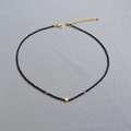 Collana minimalista con perline nere, pendente a cuore dorato e chiusura regolabile - Collana Cuore Spinello Nero