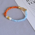 Detail of beaded necklace with blue faceted stones, orange beads and white pearls - Bracelet