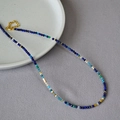 Dettaglio ravvicinato della collana di perle sfaccettate colorate con inserti dorati - Collana