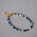 Bracciale in lapislazzuli e perle di cristallo con chiusura dorata su sfondo grigio - Bracciale
