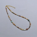 Close-up of colorful stone beads necklace with gold lobster clasp and extension chain - Necklace