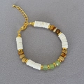 Dettaglio collana con perle di conchiglia bianca, pietre verdi e chiusura a moschettone dorata - Bracciale