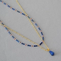 Détail du collier double rang en perles de lapis-lazuli avec un pendentif goutte dorée - Double Rang