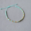 Bohemian style handmade beaded bracelet in mint green and gold with adjustable woven cord - African Pine Stone