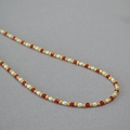 Dettaglio della collana di perle elegante con corindone rosso e perle di riso su stoffa - Collana di perle d'acqua dolce