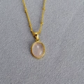 Detail of oval pink stone pendant on a gold beaded chain with elegant polished finish - Rose Quartz