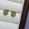Vista macro di orecchini a perno ovali in pietra naturale verde con placcatura oro - Quarzo Fragola Verde