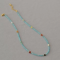 Collana artigianale di perle turchesi con accenti colorati e perla su tessuto grigio - Collana