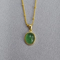 Close-up of golden satellite chain necklace with green oval gemstone pendant - Green Strawberry Quartz