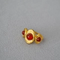 Dettaglio di anello vintage placcato oro con tre agate rosse e trama a spirale - Agata rossa