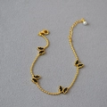 Bracelet minimaliste en plaqué or avec quatre papillons en émail noir et une perle élégante - Style de Papillon Noir