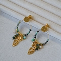 Bohemian gold hoop earrings with turquoise beads and feather pendants on white display - Earrings