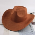 Detail of dark brown cowboy hat with adjustable chin strap placed on a lifestyle magazine - Cow Hair Brown