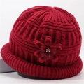 Detail van rode gebreide muts met kabelpatroon en bloemaccent met glanzende steentjes - Eén Maat (56-59cm) / Rood