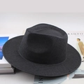 Gros plan d'un chapeau de paille noir montrant la texture tressée et le bord large plat - Noir Uni