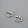 Orecchini a cerchio in argento lucido con elegante trama a treccia in vista a 45 gradi - Oro Bianco