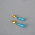 Macro detail of teardrop blue stone earrings with matte gold plating and silver pins - Blue Stone