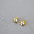 Dettaglio di orecchini a lobo dorati con texture a onde e pietra in zirconia scintillante - Oro