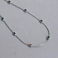 Gold plated brass necklace with multi-color rectangular gemstones on a grey textured background - Platinum Plated Necklace