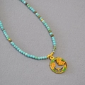 Détail du collier de perles turquoise avec pendentif floral et papillon en émail coloré - Chrysanthème de Septembre