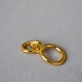 Gedetailleerde macro van drie in elkaar grijpende 18K vergulde ringen op grijze stof - US 7 / Dubbele Band (Goud)