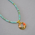 Détail du collier en perles de turquoise avec pendentif émail doré fleur et papillon - Fleur de Prunier de Décembre
