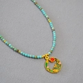 Détail du pendentif émaillé papillon fleuri et du collier de perles en turquoise - Fleur de Grenade de Mai