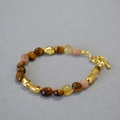 Detalle de cuentas ojo de tigre, cristales amarillos y espaciadores dorados en el collar - Pulsera