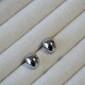 Minimalistische silberne ovale Ohrstecker mit poliertem Finish auf einem Schmucktablett - Weißgold