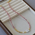 Detail of pink faceted beads with baroque pearl and golden spacers in a display tray - Rose Pink Necklace