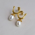 Macro view of gold-plated brass drop earrings with white pearls and fluid design - Streamlined Vintage Double Pearl Dangle Earrings (4)