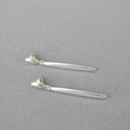 Primer plano de pendientes minimalistas de plata mate con elegante diseño de barra larga - Plata Antigua
