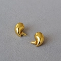 Macro shot of polished gold hollow teardrop earrings with reflective metallic finish - Gold