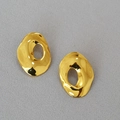 Detalle de aretes geométricos huecos dorados sobre tela gris con textura detallada - Dorado
