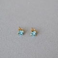 Detailed view of light blue round-cut crystal stud earrings with gold claw settings - Aquamarine