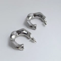Detail view of silver chunky twisted hoop earrings with a polished mirror finish on white background - Silver Irregular Twisted Wavy Stud Earrings (22)