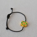 Gros plan sur le charm floral en émail vert sur un bracelet en cordon tressé noir réglable - Style Carré en Émail Vert (11)