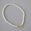 Elegante collar de perlas barrocas de agua dulce con cierre OT dorado en tela gris - Collar